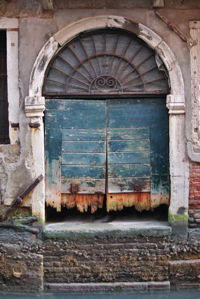 Weathered doorway on a canal in Venice, Italy