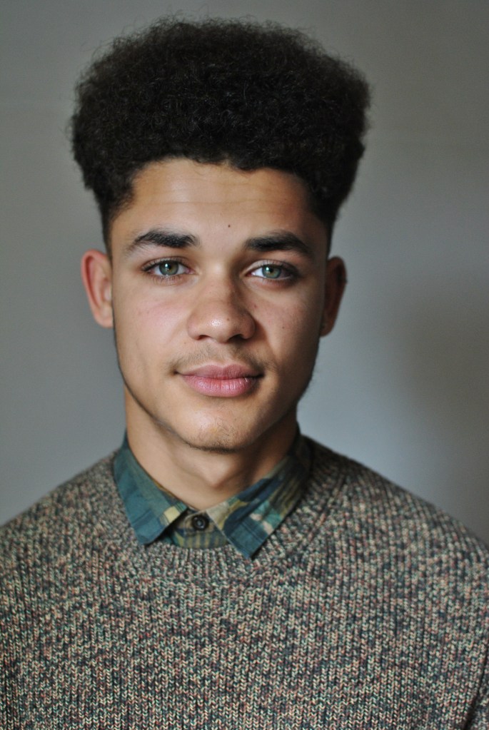 Portrait of young man in knitted jumper and shirt 