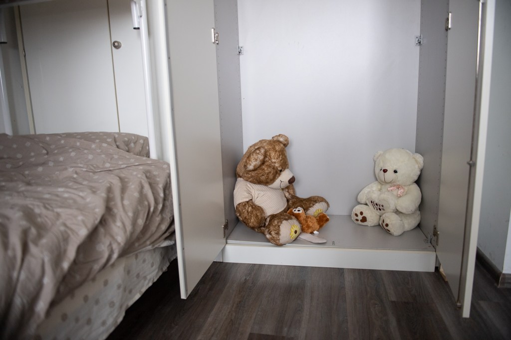 Two teddy bears inside a wardrobe left for children to find in a refugee centre, Romania